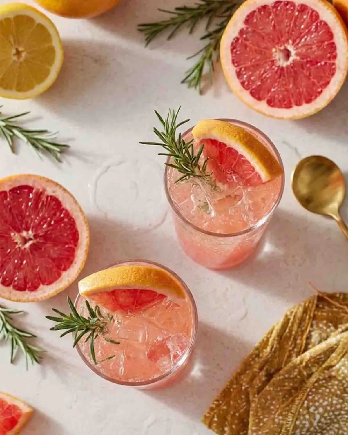 Zest for Life: Citrus Sparkler Mocktail - A Refreshing Blend of Citrus Delights! 3 Top view of Citrus Sparkler Mocktail with grapefruit slices, rosemary garnish, ice, and sparkling citrus drink