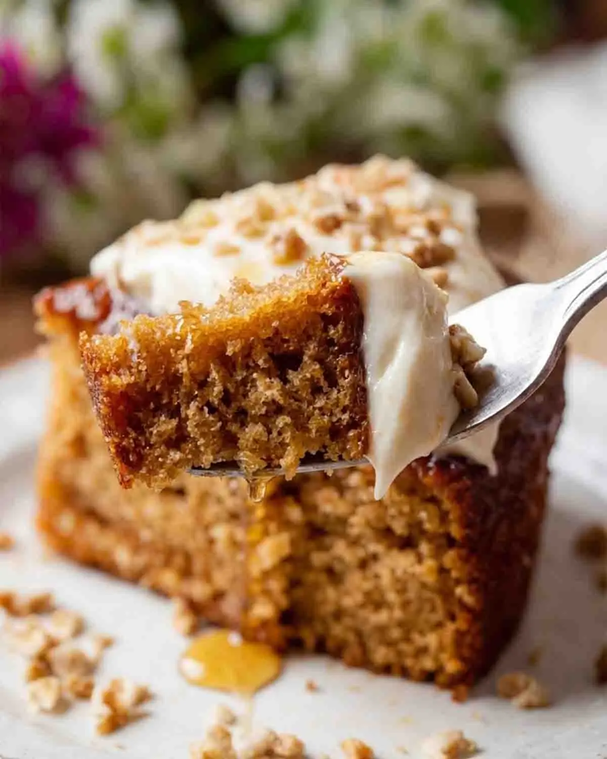 Sweet Sensation: Baking the Perfect Honey Cake 4 Honey cake slice on fork with cream topping and honey drizzle, showing moist texture