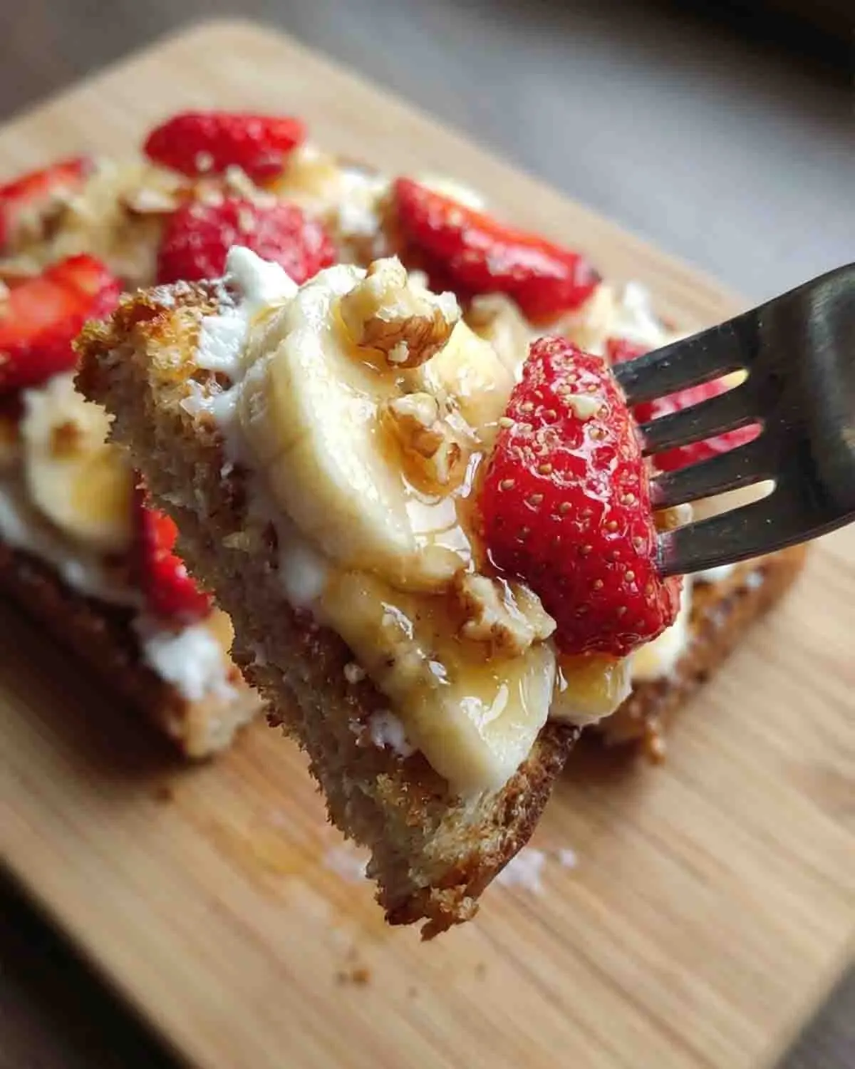 Strawberry Banana Toast: A Burst of Sweetness to Brighten Your Day 3 Strawberry banana toast topped with sliced bananas, fresh strawberries, creamy spread, crunchy granola, and a drizzle of honey on toasted bread, served as a healthy breakfast.