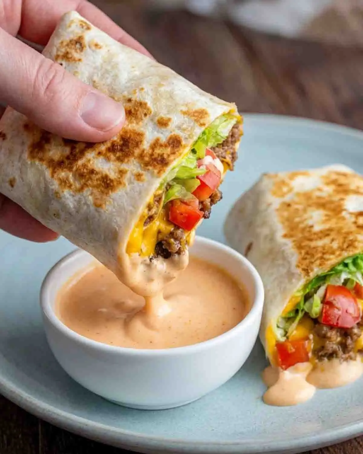 Air Fryer Cheeseburger Wraps 3 close-up of air fryer cheeseburger wrap with melted cheese and ground beef filling, partially visible on screen with distorted overlay