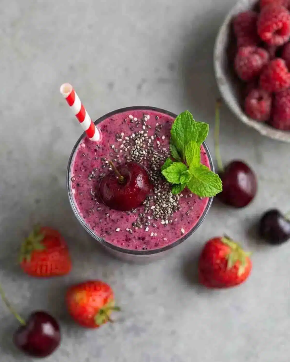 Berry, Chia, and Mint Smoothie 4 Berry, Chia, and Mint Smoothie topped with chia seeds, fresh mint, and cherry in a glass with strawberries and raspberries